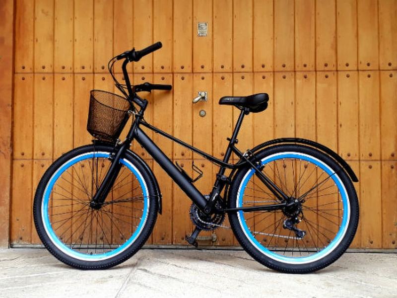 Bicicleta urbana negra con rines azules y canasta, ejemplo de bicicleta institucional